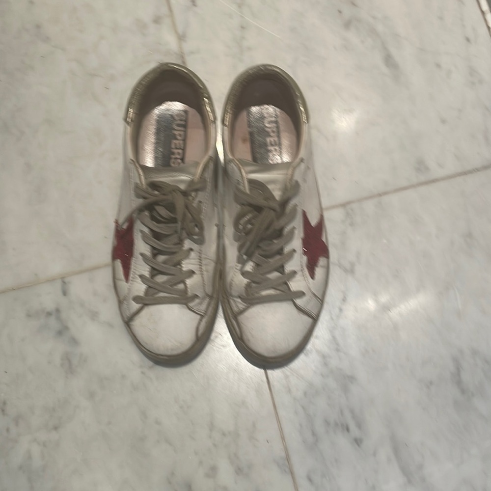 Golden goose sneakers with red sequin star.